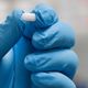 A pill of hydroxychloroquine being held by a pharmacy tech.